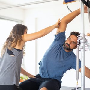 A Woman Guiding an Exercising Man